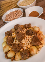 Moughrabieh is a popular dish in the Lebanese cuisine, LEBANESE RECIPE FOR MOUGHRABIEH WITH BEEF AND SMALL ONIONS, SEMOLINA PEARLS AND CHICKPEAS. High quality photo