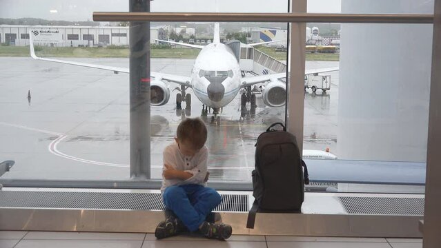 Mallorca, Spain - August 10 2016: Tired and angry little boy near the luggage in the airport after airplane flight cancelation