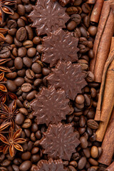 Food background. Coffee beans, cinnamon sticks, anise stars and chocolate candies top view.