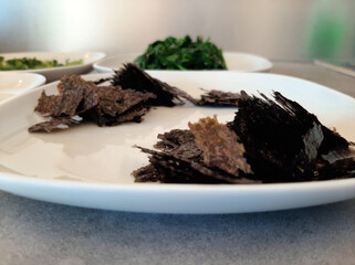 Dried nori algae served on white a plate