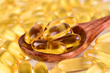 Omega 3 capsules in a wooden spoon. Close-up. Useful vitamins.
