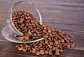 Cup of coffee full of coffee beans on a dark wooden background.Copy space.
