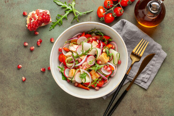 Salad with grilled salmon, fresh green  leaves, cucumber, tomatoes, pepper, radish, pomergranate and red onion . Healthy lunch salad. Top view