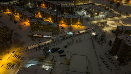 Drone photography of parking place near a building and snow covered cars during winter morning