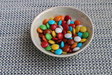 A small bowl with colorful dragees. Multicolored dragee candies.