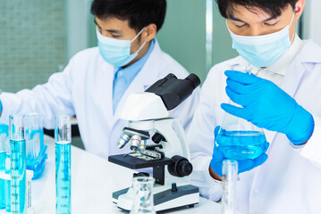 Scientist man look into Microscope research in science laboratory. Asian scientist looking...