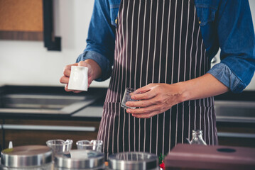 Coffee barista man make espresso shot from coffee maker hot cup. Cappuccino with milk in italian coffee shop cafe. Close up hands of barista use machine make brown latte art for customer cafeteria