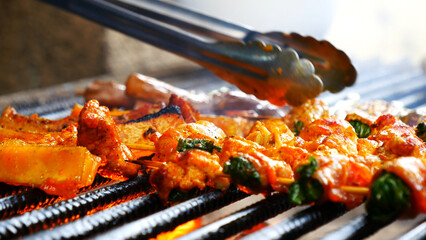 BBQ Barbecue grilled meat stick on fire flame with hot charcoal cooking outside. Beef grilling...