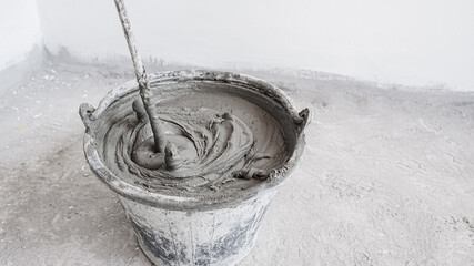 Cement mix in bucket for masonry plaster - obrazy, fototapety, plakaty