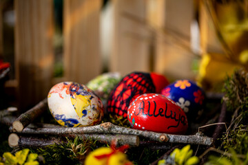 A Serene Easter Display: Handcrafted Eggs Amidst Natural Surroundings and Soft Light - obrazy, fototapety, plakaty