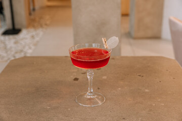 Red fresh cocktail in transparent glass on table isolated on background