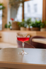 Red fresh cocktail in transparent glass on table isolated on background