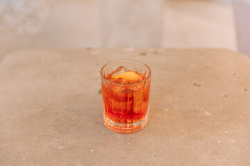 Negroni cocktail with ice in transparent glass on restaurant table isolated on background
