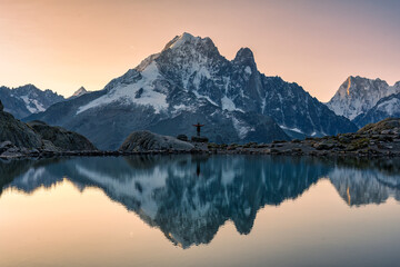 French alps landscape of Lac Blanc with Mont Blanc massif with male traveler reflected on the lake...