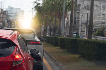 Traffic jam on the road in the city at sunset. Close up rear side of red car with turn on brake...