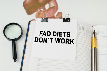 On the table there is a magnifying glass and a notepad with the inscription - Fad Diets Dont Work