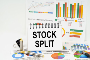 On the table are reports with graphs and a notepad with the inscription - Stock split