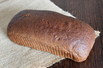 loaf of rye bread on burlap background