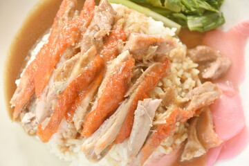 slice roasted duck topping rice with pink pickled ginger and boiled cabbage dressing sweet soy sauce on plate