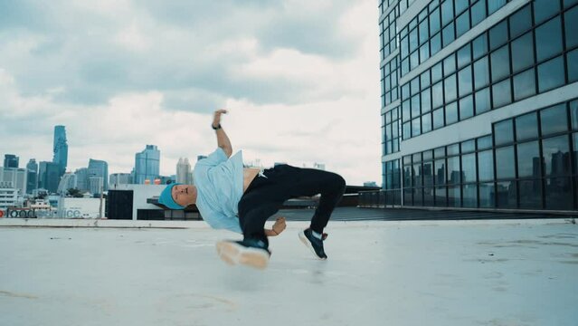 Stylish caucasian dancing man performing break dance at skyscraper. Portrait image of young happy man practicing dance performance choreographer in modern urban city. Outdoor sport 2024.. hiphop.