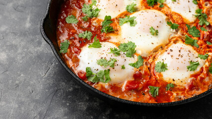 Healthy shakshuka with vegetables, herbs, tomatoes in iron cast pan