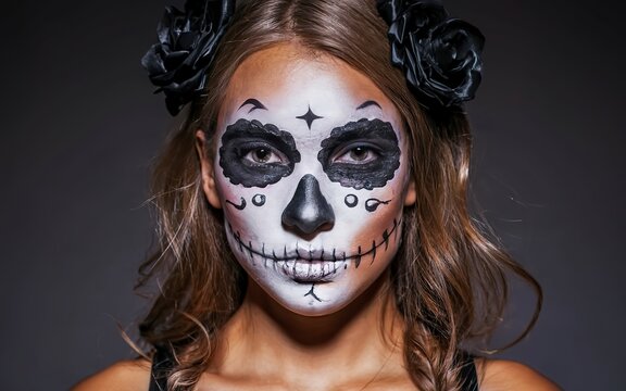 Girl with Halloween face art on white background