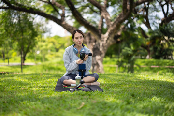 Female Social Media Influencer Demonstrates Massage Gun Usage in a Serene Park Setting