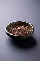 Dry root of Rhodiola rosea. Golden root, rose root. Healthy medical plant on dark paper background. Close up. Copy space.	