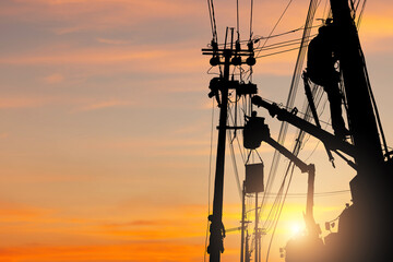 Silhouette of Electrician officer climbs a pole and uses a cable car to maintain a high voltage line system, Shadow of Electrician lineman repairman worker at climbing work on electric post power pole