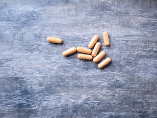 Lutein capsules. Dietary supplement on wooden background. Soft focus. Top view. Close up. Copy...