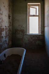 Antique bathtub sits at the heart of an abandoned building in a n old desert town
