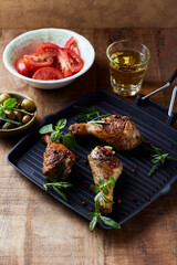 Spicy chicken drumsticks with fresh herbs. Close up.	