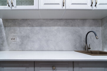 sink with tap in the kitchen with a decorative wall made of plaster in gray color