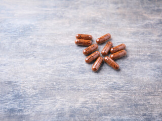 Korean Ginseng capsules. Concept for a healthy dietary supplementation. Bright wooden background. Copy space.	