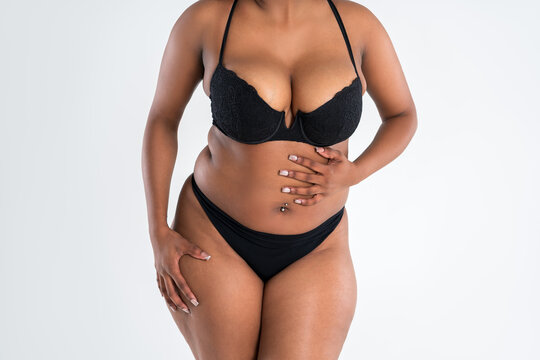 Curvy busty plus size model in push up bra on gray background, overweight African black woman in sexy lingerie, fat body