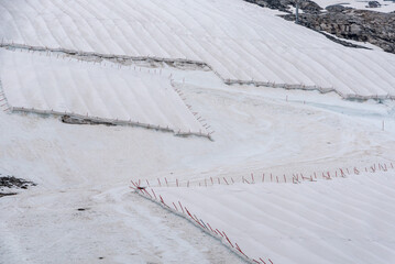 A large snow tarpaulin protecting the ice of the Hintertux glacier in the Alps, a ski slope is...