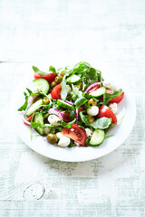 Summer Salad with Mozzarella Cheese, Tomatoes and fresh Basil. Bright wooden background.