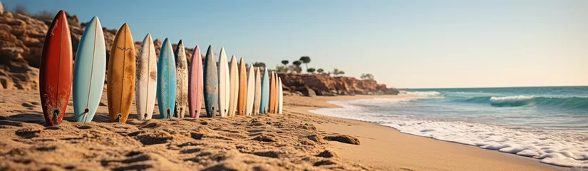 Fotobehang Surfboards on the sandy beach at sunset, panoramic banner. Surfboards on the beach. Vacation Concept with Copy Space. © John Martin