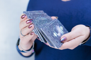 Female hands holding tarot cards for fortune telling and tricks