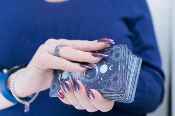 Female hands holding tarot cards for fortune telling and tricks