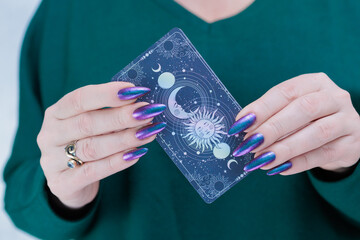 Female hands holding tarot cards for fortune telling and tricks