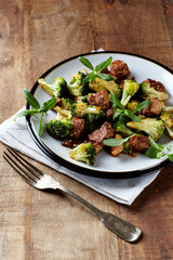 Duck and Broccoli Stir-Fry (with soy sauce and sesame oil). Wooden background. Close up.	