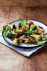 Duck and Broccoli Stir-Fry (with soy sauce and sesame oil). Wooden background. Close up.