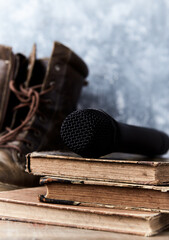 Obraz premium Modern microphone lying on old books. Close up. Copy space.