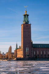 The old town hall of Stockholm in Kungsholmen district in the winter, ice on the lake, blue sky...