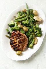 Grilled Turkey Breast with oven baked potatoes and broccoli. Bright wooden background. Close up.	