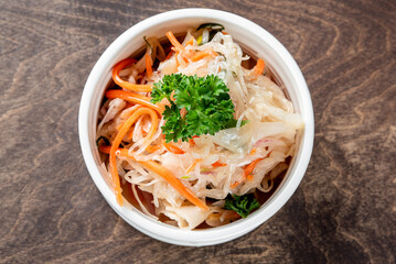 pickled cabbage and carrots in a white plate on the table
