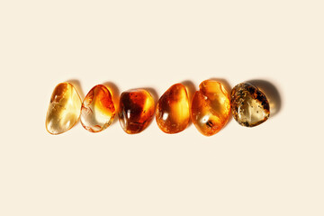 Set of amber stones gradient color on beige background, style minimal design concept, trend pattern. Natural gemstones aesthetic nature stones yellow gradient colors. Minimalist style