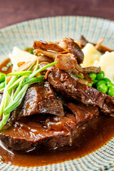 Stewed beef veal cheeks with mashed potatoes on plate