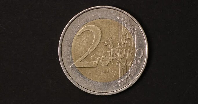 Used two euro coins of different age changing on dark background. Big closeup of changing coins. Money, Cash, Timelapse, Finance concept. 4K stop motion animation.